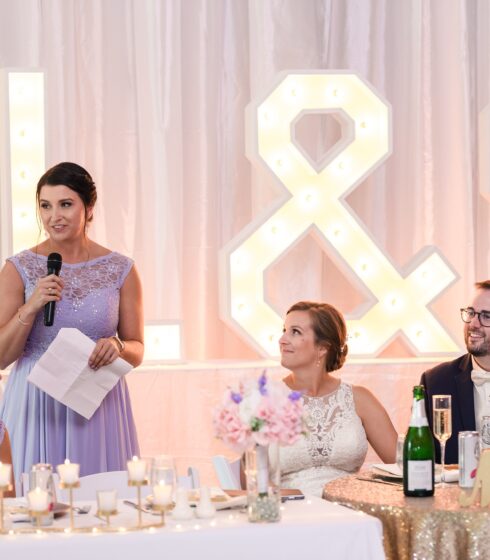 Maid of honor giving a speech in a light purple, full-length dress.