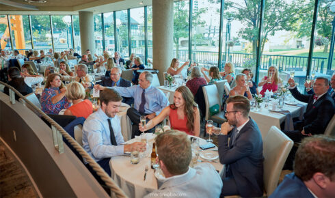 People sitting at round tables and celebrating at The Coast